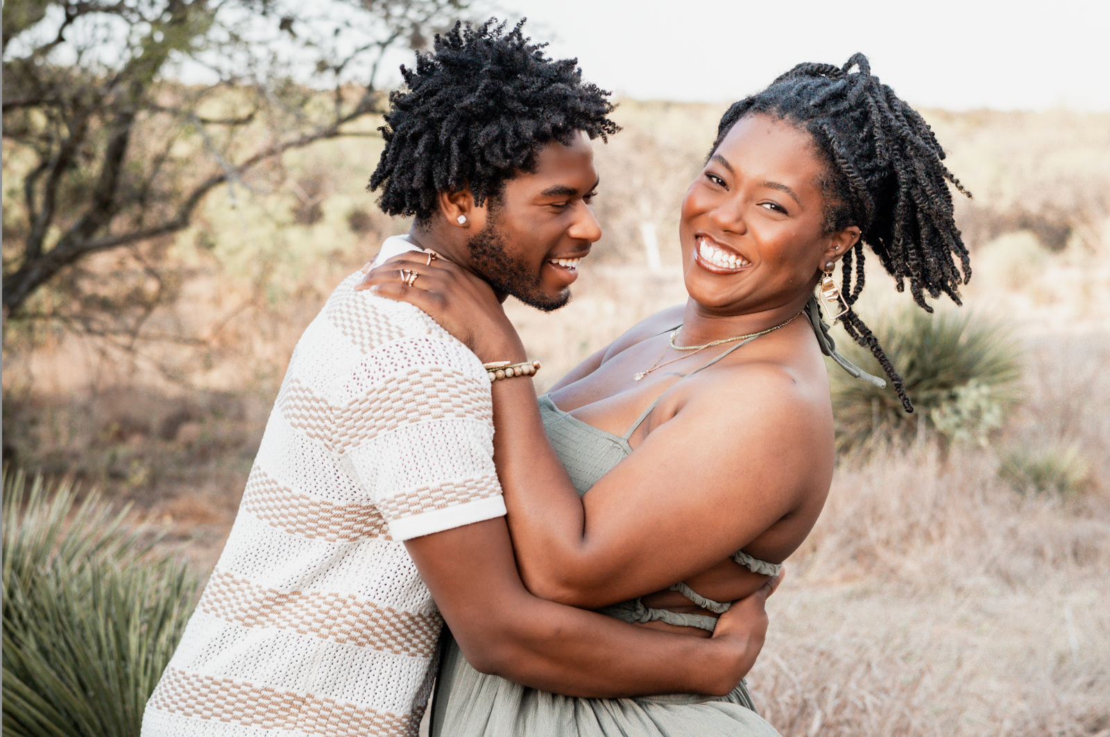 Couple laughing and embracing in the desert among yucca plants